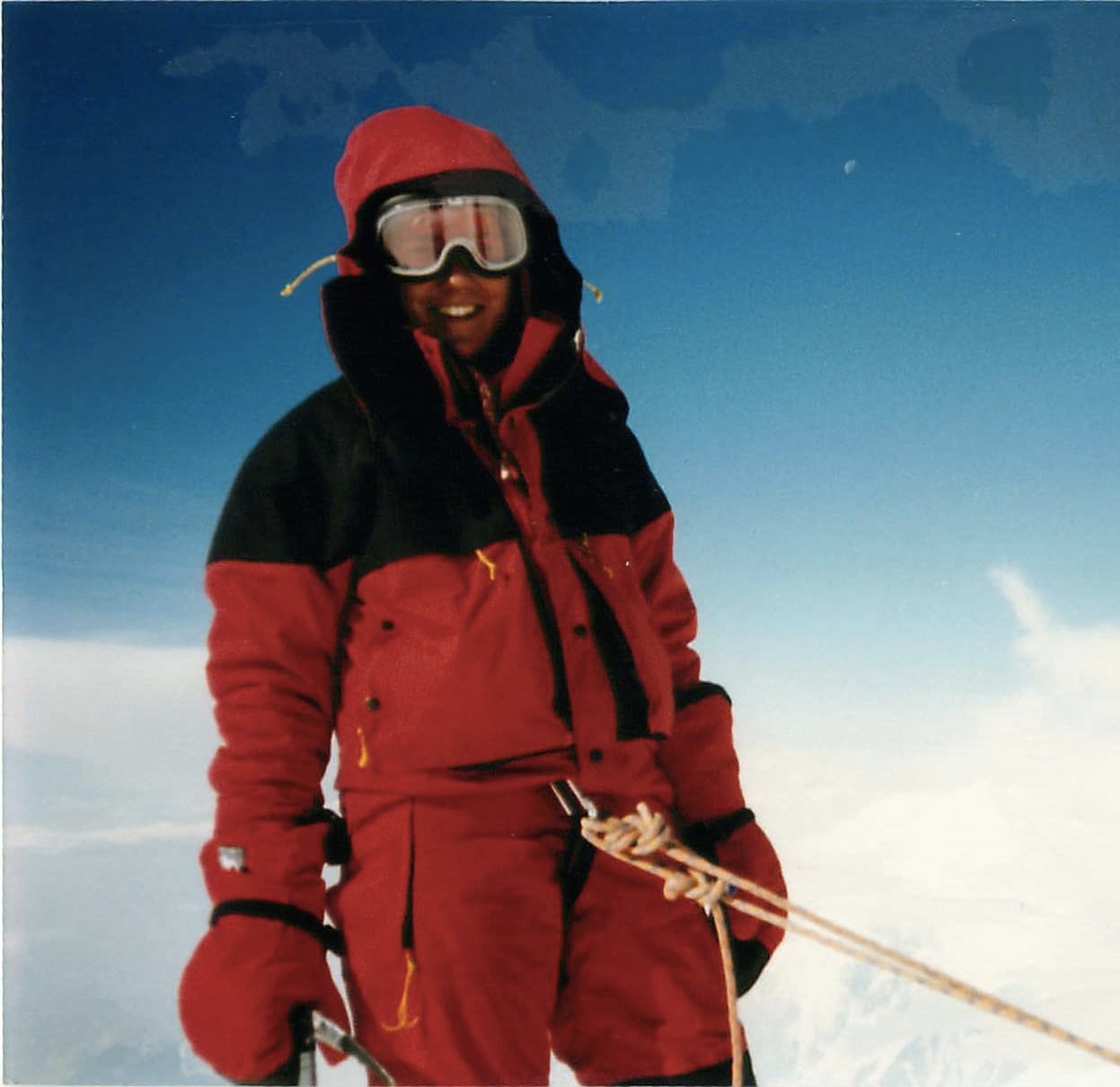 A climber in a red parka and goggles on Denali