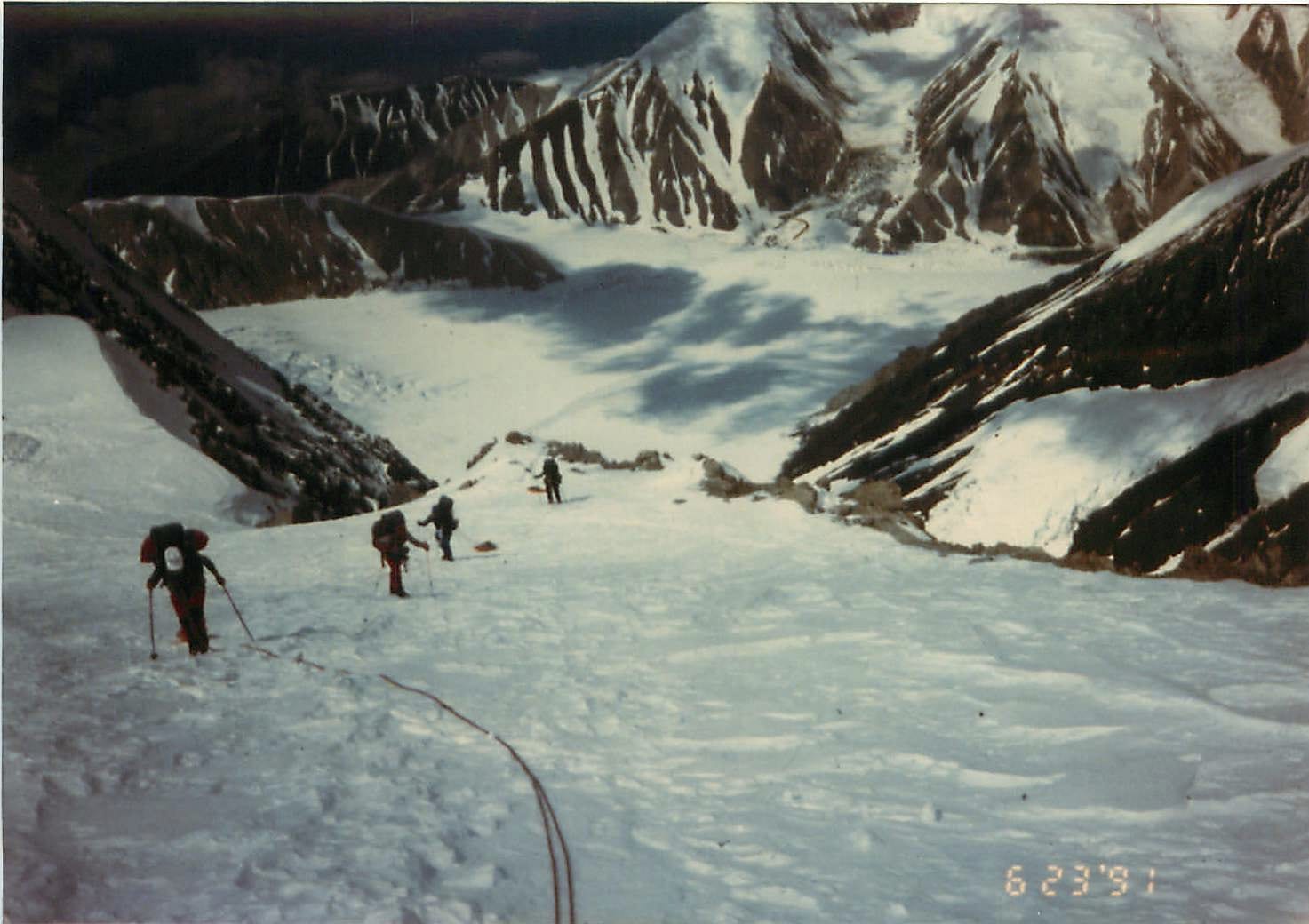 A rope team climbs a snowy glacier on Denali